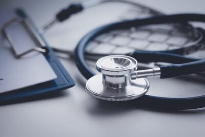 blue stethoscope on desk with medical notes in the background